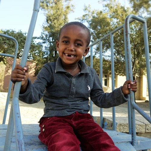äthiopisches Kind beim Spielen auf Klettergerüst